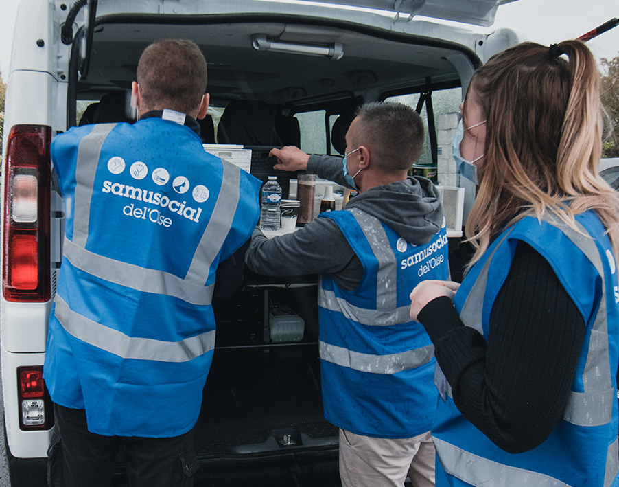 Trois bénévoles du Samu social de l'Oise s'occupent de la distribution de repas solidaires en prenant de l'alimentaire dans la camionnette.